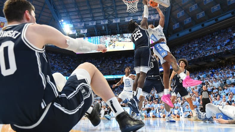 Feb 3, 2024; Chapel Hill, North Carolina, USA; North Carolina Tar Heels forward Armando Bacot (5) shoots as Duke Blue Devils forward Mark Mitchell (25) defends and center Kyle Filipowski (30) sits on the floor in the second half at Dean E. Smith Center. Mandatory Credit: Bob Donnan-USA TODAY Sports