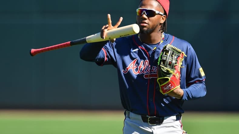 Atlanta Braves outfielder Ronald Acuna, Jr. makes a sign for a video drone following players as the enter the stadium for the first full squad workout on Tuesday, Feb. 20, 2024 at CoolToday Park in North Port, Florida.