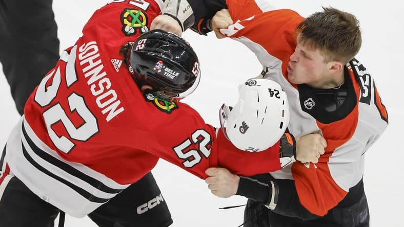Feb 21, 2024; Chicago, Illinois, USA; Philadelphia Flyers defenseman Nick Seeler (24) fights with Chicago Blackhawks center Reese Johnson (52) during the third period at United Center. Mandatory Credit: Kamil Krzaczynski-USA TODAY Sports