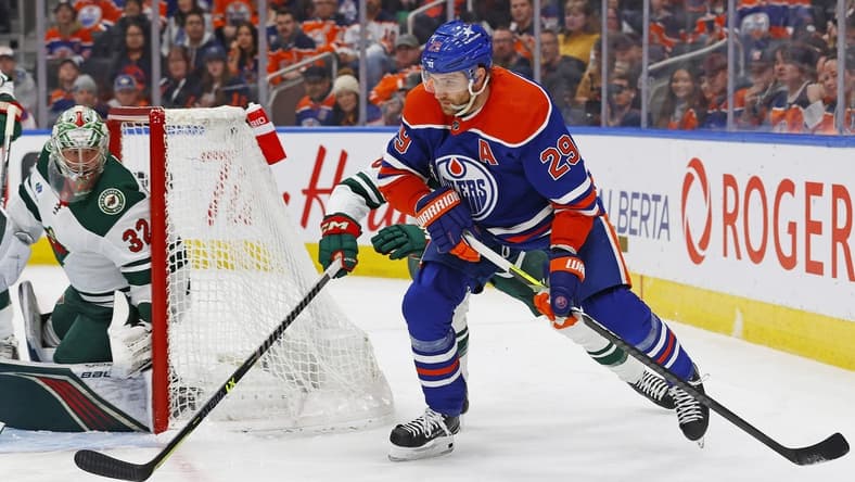 Feb 23, 2024; Edmonton, Alberta, CAN; Edmonton Oilers forward Leon Draisaitl (29) looks to make a pass in front of Minnesota Wild defensemen Dakota Mermis (6) during the first period at Rogers Place. Mandatory Credit: Perry Nelson-USA TODAY Sports