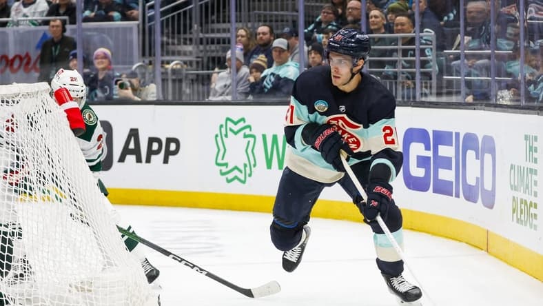 Feb 24, 2024; Seattle, Washington, USA; Seattle Kraken center Alex Wennberg (21) skates with the puck behind the net against the Minnesota Wild during the third period at Climate Pledge Arena. Mandatory Credit: Joe Nicholson-USA TODAY Sports