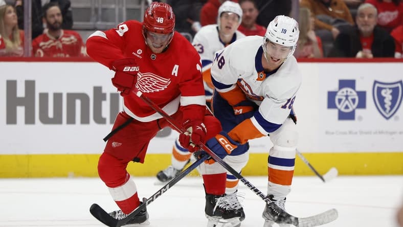 Feb 29, 2024; Detroit, Michigan, USA;  Detroit Red Wings center Andrew Copp (18) and New York Islanders left wing Pierre Engvall (18) battle for the puck in the third period at Little Caesars Arena. Mandatory Credit: Rick Osentoski-USA TODAY Sports