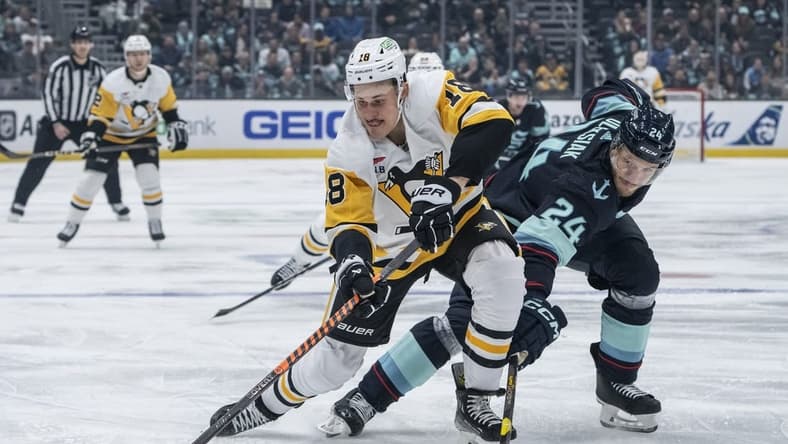 Feb 29, 2024; Seattle, Washington, USA; Pittsburgh Penguins forward Jesse Puljujarvi (18) and Seattle Kraken defenseman Jamie Oleksiak (24) battle for the puck during the first period at Climate Pledge Arena. Mandatory Credit: Stephen Brashear-USA TODAY Sports