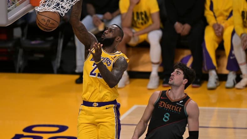 Feb 29, 2024; Los Angeles, California, USA; Los Angeles Lakers forward LeBron James (23) moves past Washington Wizards forward Deni Avdija (8) for a dunk in the first half at Crypto.com Arena. Mandatory Credit: Jayne Kamin-Oncea-USA TODAY Sports