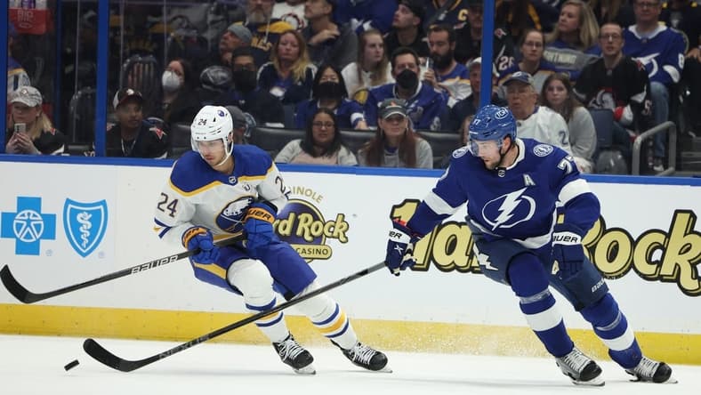 Feb 29, 2024; Tampa, Florida, USA;  Tampa Bay Lightning defenseman Victor Hedman (77) and Buffalo Sabres center Dylan Cozens (24) fight for the puck in the second period at Amalie Arena. Mandatory Credit: Nathan Ray Seebeck-USA TODAY Sports