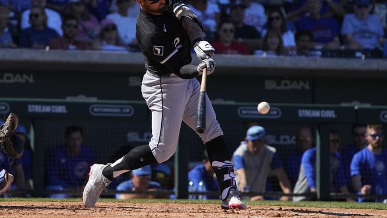 Mar 1, 2024; Mesa, Arizona, USA; Chicago White Sox right fielder Kevin Pillar (12) hits a double against the Chicago Cubs during the third inning at Sloan Park. Mandatory Credit: Rick Scuteri-USA TODAY Sports