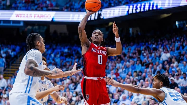 Mar 2, 2024; Chapel Hill, North Carolina, USA; North Carolina State Wolfpack guard DJ Horne (0) shoots between North Carolina Tar Heels forward Armando Bacot (5) (left) and forward Harrison Ingram (55) during the first half at Dean E. Smith Center. Mandatory Credit: Scott Kinser-USA TODAY Sports