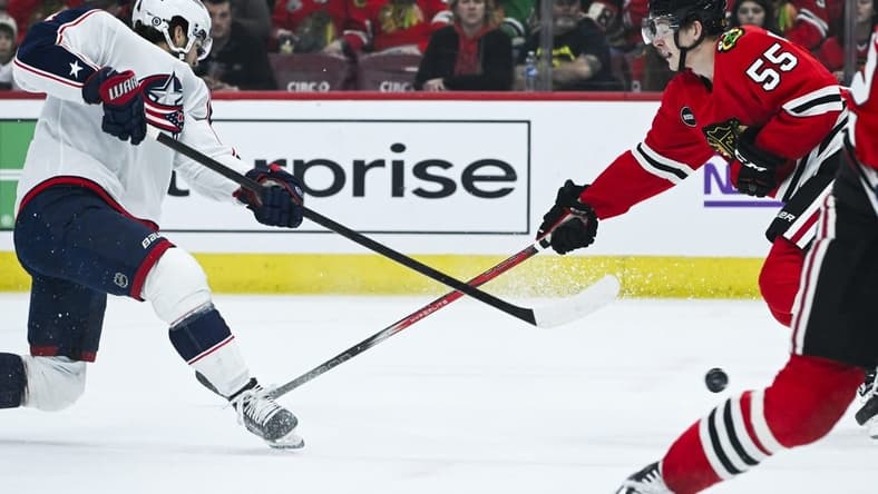 Mar 2, 2024; Chicago, Illinois, USA; Columbus Blue Jackets center Cole Sillinger (4) shoots the puck against Chicago Blackhawks defenseman Kevin Korchinski (55) during the first period at the United Center. Mandatory Credit: Matt Marton-USA TODAY Sports