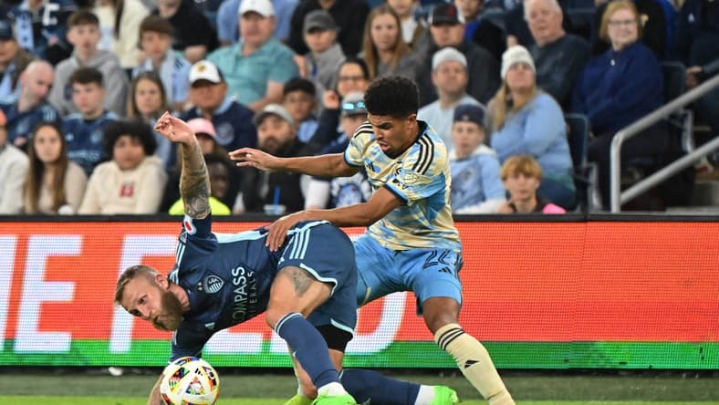 Mar 2, 2024; Kansas City, Kansas, USA; Sporting Kansas City forward Johnny Russell (7) battles Philadelphia Union defender Nathan Harriel (26) for the ball in the first half at Children's Mercy Park. Mandatory Credit: Peter Aiken-USA TODAY Sports