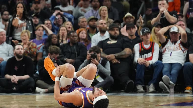 Mar 2, 2024; Phoenix, Arizona, USA; Phoenix Suns guard Devin Booker (1) reacts after being inured against the Houston Rockets during the second half at Footprint Center. Mandatory Credit: Joe Camporeale-USA TODAY Sports