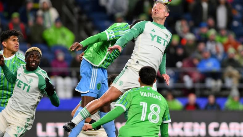 Mar 2, 2024; Seattle, Washington, USA; Austin FC midfielder Alex Ring (8) heads the ball in the second half against the Seattle Sounders FC at Lumen Field. Mandatory Credit: Steven Bisig-USA TODAY Sports