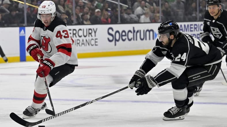 Mar 3, 2024; Los Angeles, California, USA;  New Jersey Devils defenseman Luke Hughes (43) and Los Angeles Kings center Phillip Danault (24) battle for the puck in the first period at Crypto.com Arena. Mandatory Credit: Jayne Kamin-Oncea-USA TODAY Sports