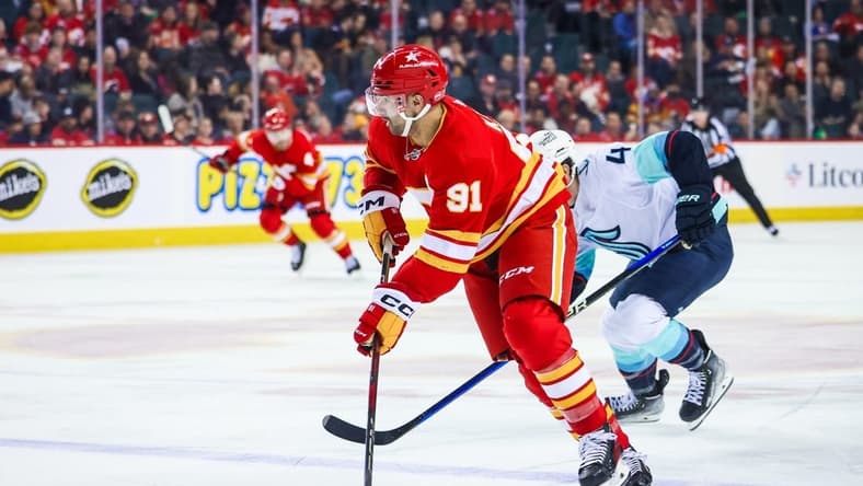 Mar 4, 2024; Calgary, Alberta, CAN; Calgary Flames center Nazem Kadri (91) controls the puck against the Seattle Kraken during the second period at Scotiabank Saddledome. Mandatory Credit: Sergei Belski-USA TODAY Sports