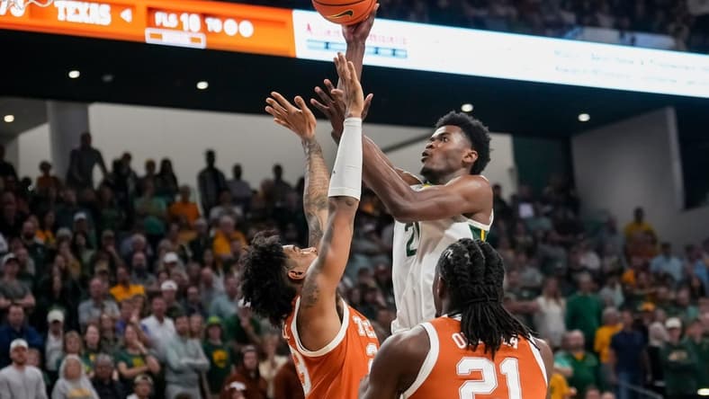 Mar 4, 2024; Waco, Texas, USA; Baylor Bears center Yves Missi (21) scores a basket over Texas Longhorns forward Dillon Mitchell (23) during the second half at Paul and Alejandra Foster Pavilion. Mandatory Credit: Chris Jones-USA TODAY Sports