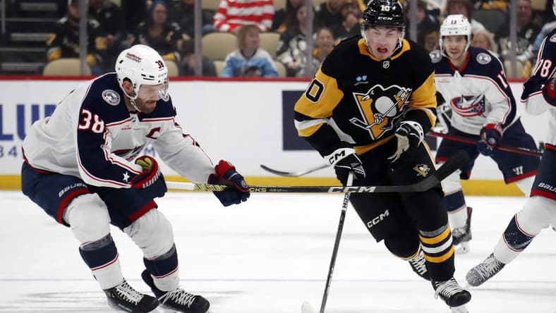 Mar 5, 2024; Pittsburgh, Pennsylvania, USA; Pittsburgh Penguins left wing Drew O'Connor (10) moves the puck up ice against Columbus Blue Jackets center Boone Jenner (38) during the first period at PPG Paints Arena. Mandatory Credit: Charles LeClaire-USA TODAY Sports