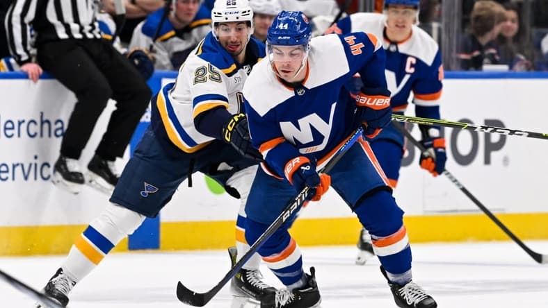 Mar 5, 2024; Elmont, New York, USA; New York Islanders center Jean-Gabriel Pageau (44) and St. Louis Blues center Jordan Kyrou (25) battle for a loose puck during the first period at UBS Arena. Mandatory Credit: Dennis Schneidler-USA TODAY Sports
