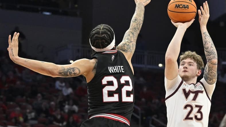 Mar 5, 2024; Louisville, Kentucky, USA; Virginia Tech Hokies guard Tyler Nickel (23) shoots against Louisville Cardinals guard Tre White (22) during the first half at KFC Yum! Center. Mandatory Credit: Jamie Rhodes-USA TODAY Sports