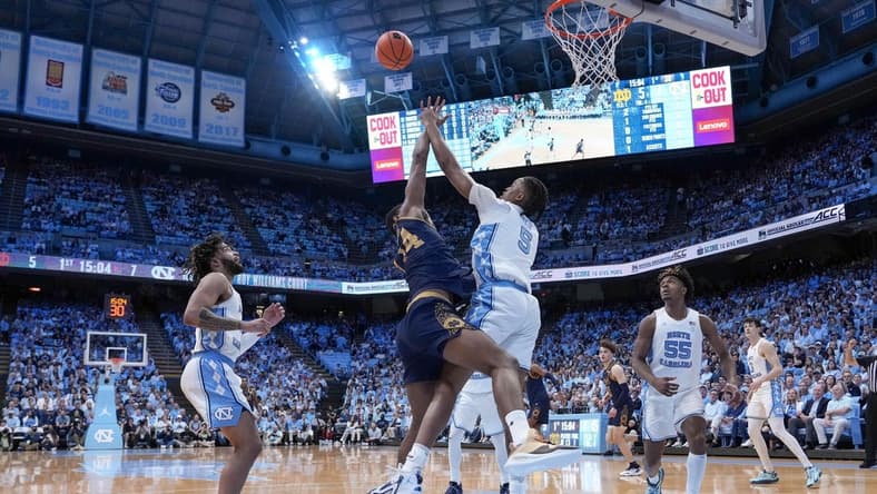 Mar 5, 2024; Chapel Hill, North Carolina, USA; Notre Dame Fighting Irish forward Kebba Njie (14) has his shot blocked by North Carolina Tar Heels forward Armando Bacot (5) during the first half at Dean E. Smith Center. Mandatory Credit: Jim Dedmon-USA TODAY Sports