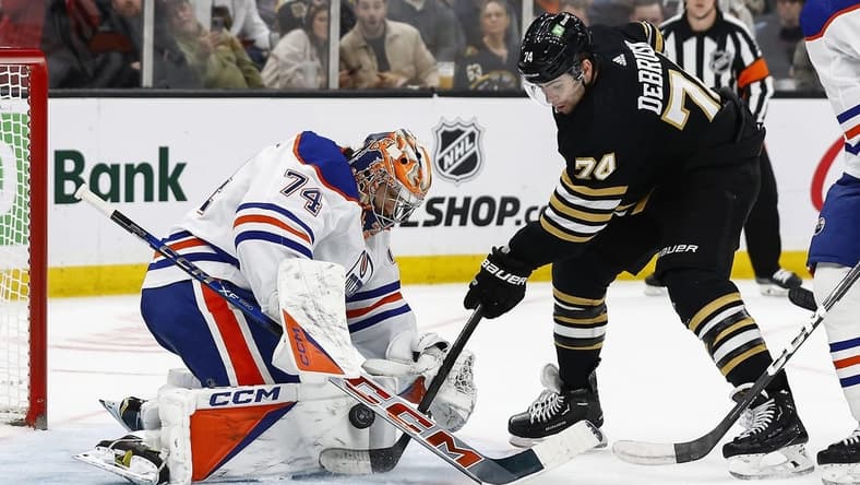 Mar 5, 2024; Boston, Massachusetts, USA; Boston Bruins left wing Jake DeBrusk (74) jams at a rebound at the crease of Edmonton Oilers goaltender Stuart Skinner (74) during the second period at TD Garden. Mandatory Credit: Winslow Townson-USA TODAY Sports