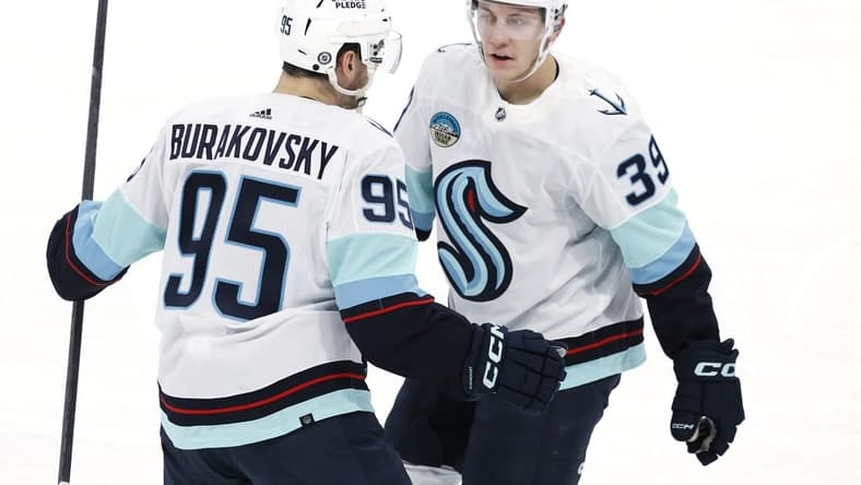 Mar 5, 2024; Winnipeg, Manitoba, CAN; Seattle Kraken left wing Andre Burakovsky (95) celebrates his third period goal with  Seattle Kraken defenseman Ryker Evans (39) against the Winnipeg Jets at Canada Life Centre. Mandatory Credit: James Carey Lauder-USA TODAY Sports