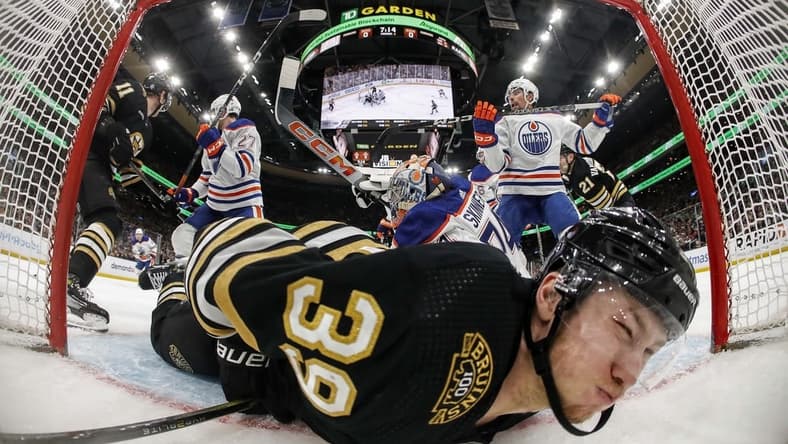 Mar 5, 2024; Boston, Massachusetts, USA; Boston Bruins center Morgan Geekie (39) is dumped into the Edmonton Oilers net during the second period at TD Garden. Mandatory Credit: Winslow Townson-USA TODAY Sports