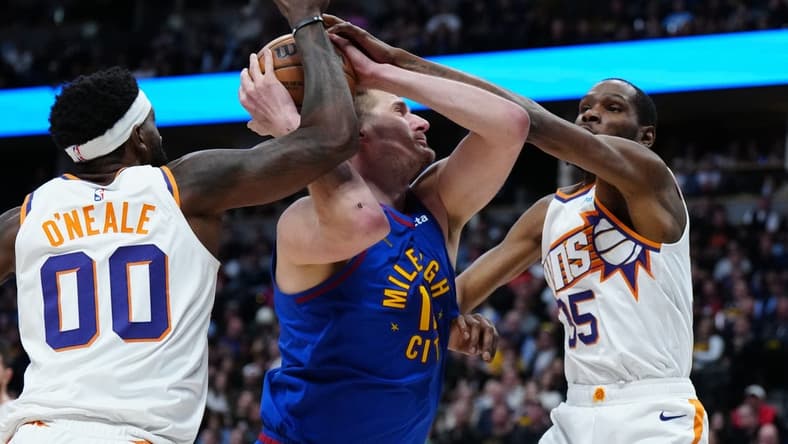 Mar 5, 2024; Denver, Colorado, USA; Phoenix Suns forward Kevin Durant (35) and forward Royce O'Neale (00) defend Denver Nuggets center Nikola Jokic (15) in the first half at Ball Arena. Mandatory Credit: Ron Chenoy-USA TODAY Sports
