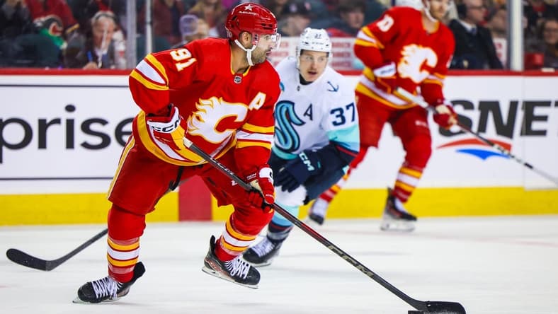 Mar 4, 2024; Calgary, Alberta, CAN; Calgary Flames center Nazem Kadri (91) controls the puck against the Seattle Kraken during the third period at Scotiabank Saddledome. Mandatory Credit: Sergei Belski-USA TODAY Sports