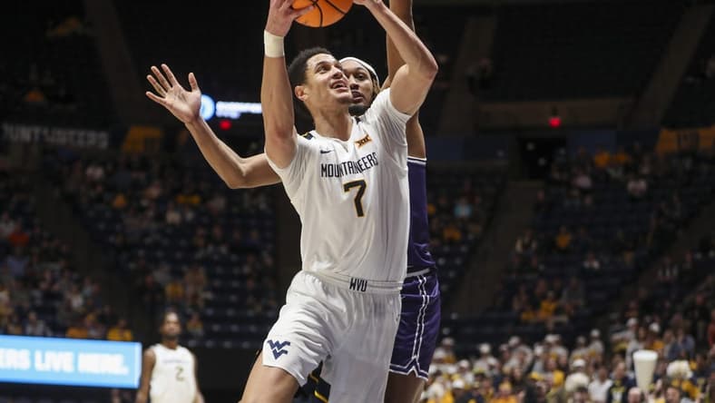 Mar 6, 2024; Morgantown, West Virginia, USA; West Virginia Mountaineers center Jesse Edwards (7) shoots against TCU Horned Frogs forward Xavier Cork (12) during the second half at WVU Coliseum. Mandatory Credit: Ben Queen-USA TODAY Sports