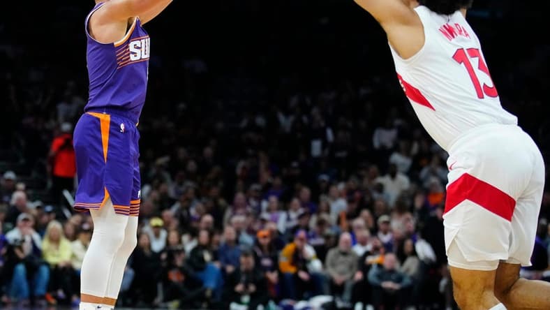Suns guard Grayson Allen (8) makes a three pointer against Raptors forward Jordan Nwora (13) during a game at the Footprint Center.