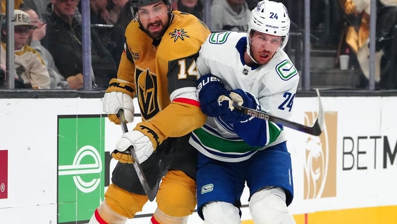 Mar 7, 2024; Las Vegas, Nevada, USA; Vegas Golden Knights defenseman Nicolas Hague (14) checks Vancouver Canucks center Pius Suter (24) during the first period at T-Mobile Arena. Mandatory Credit: Stephen R. Sylvanie-USA TODAY Sports