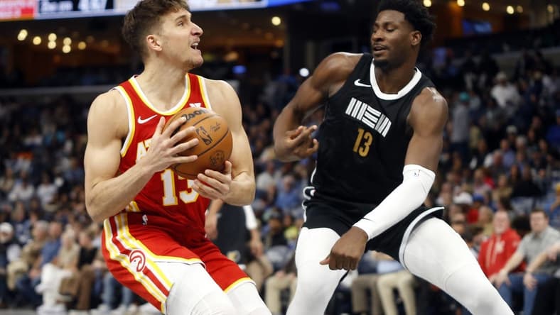 Mar 8, 2024; Memphis, Tennessee, USA; Atlanta Hawks guard Bogdan Bogdanovic (13) drives to the basket as Memphis Grizzlies forward-center Jaren Jackson Jr. (13) defends during the first half at FedExForum. Mandatory Credit: Petre Thomas-USA TODAY Sports