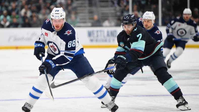 Mar 8, 2024; Seattle, Washington, USA; Winnipeg Jets defenseman Nate Schmidt (88) advances the puck while defended by Seattle Kraken right wing Jordan Eberle (7) during the first period at Climate Pledge Arena. Mandatory Credit: Steven Bisig-USA TODAY Sports