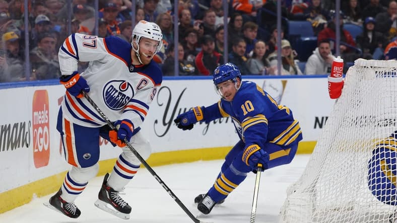 Mar 9, 2024; Buffalo, New York, USA;  Edmonton Oilers center Connor McDavid (97) plays the puck behind the net as Buffalo Sabres defenseman Henri Jokiharju (10) tries to defend during the first period at KeyBank Center. Mandatory Credit: Timothy T. Ludwig-USA TODAY Sports