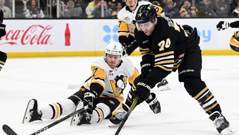 Mar 9, 2024; Boston, Massachusetts, USA; Boston Bruins left wing Jake DeBrusk (74) skates against Pittsburgh Penguins defenseman John Ludvig (7) during the first period at the TD Garden. Mandatory Credit: Brian Fluharty-USA TODAY Sports