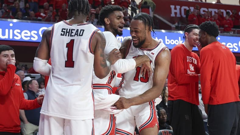 Mar 9, 2024; Houston, Texas, USA; Houston Cougars forward J'Wan Roberts (13) celebrates with guard Mylik Wilson (8) and guard Jamal Shead (1) in the final minute of the game against the Kansas Jayhawks at Fertitta Center. Mandatory Credit: Troy Taormina-USA TODAY Sports