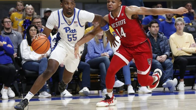 Mar 9, 2024; Pittsburgh, Pennsylvania, USA; Pittsburgh Panthers forward Zack Austin (55) drives the baseline against North Carolina State Wolfpack guard Casey Morsell (14) during the first half at the Petersen Events Center. Mandatory Credit: Charles LeClaire-USA TODAY Sports