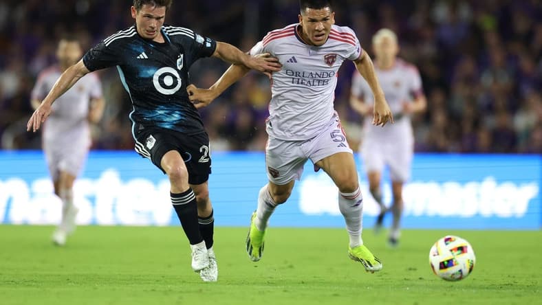 Mar 9, 2024; Orlando, Florida, USA; Orlando City midfielder Cesar Araujo (5) battles for the ball with Minnesota United midfielder Wil Trapp (20) during the first half at Inter & Co Stadium. Mandatory Credit: Nathan Ray Seebeck-USA TODAY Sports