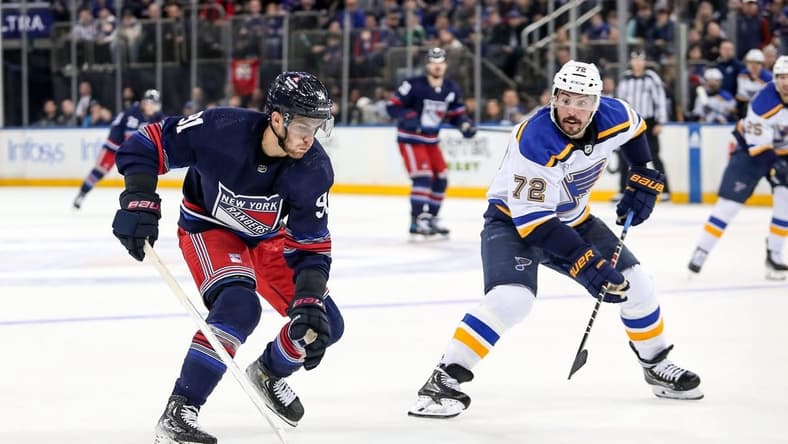 Mar 9, 2024; New York, New York, USA; New York Rangers center Alex Wennberg (91) skates in with the puck against St. Louis Blues defenseman Justin Faulk (72) who was called for hooking during the second period at Madison Square Garden. Mandatory Credit: Danny Wild-USA TODAY Sports