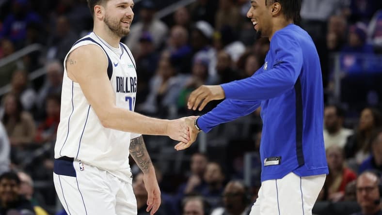 Mar 9, 2024; Detroit, Michigan, USA; Dallas Mavericks guard Luka Doncic (77) receives congratulations from guard A.J. Lawson (9) in the second half against the Detroit Pistons at Little Caesars Arena. Mandatory Credit: Rick Osentoski-USA TODAY Sports