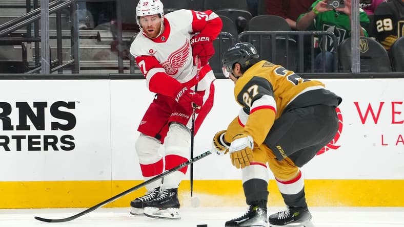 Mar 9, 2024; Las Vegas, Nevada, USA; Detroit Red Wings left wing J.T. Compher (37) makes a pass in front of Vegas Golden Knights defenseman Shea Theodore (27) during the first period at T-Mobile Arena. Mandatory Credit: Stephen R. Sylvanie-USA TODAY Sports