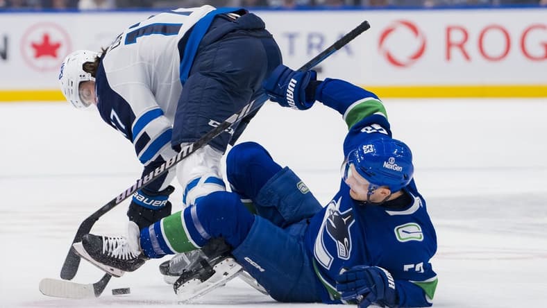 Mar 9, 2024; Vancouver, British Columbia, CAN; Winnipeg Jets forward Adam Lowry (17) checks Vancouver Canucks forward Teddy Blueger (53) in the first period at Rogers Arena. Mandatory Credit: Bob Frid-USA TODAY Sports