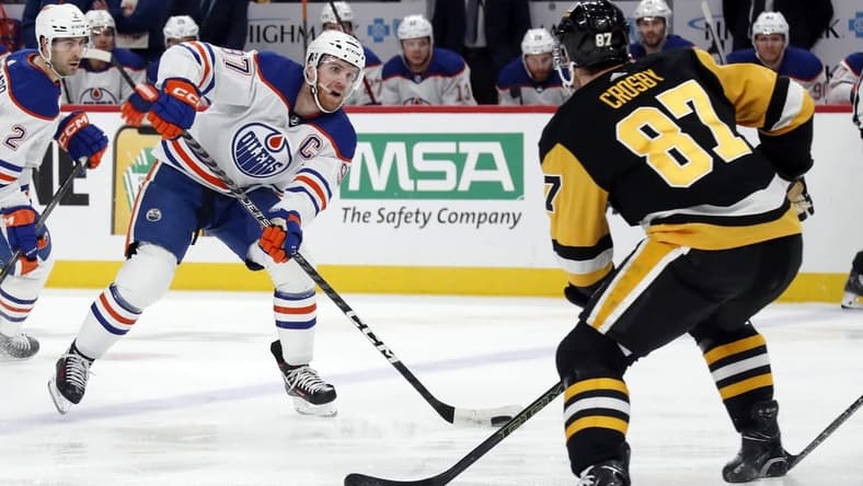 Mar 10, 2024; Pittsburgh, Pennsylvania, USA;  Edmonton Oilers center Connor McDavid (97) skates with the puck as Pittsburgh Penguins Pittsburgh Penguins center Sidney Crosby (87) defends during the second period at PPG Paints Arena. Mandatory Credit: Charles LeClaire-USA TODAY Sports