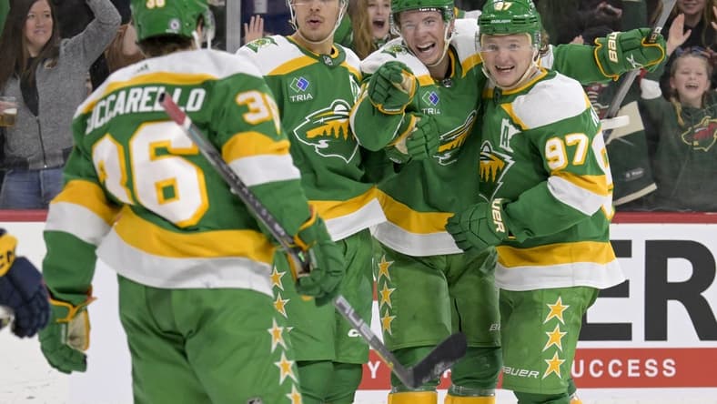 Mar 10, 2024; Saint Paul, Minnesota, USA;  Minnesota Wild forward Matt Boldy (12) points to forward Mats Zuccarello (36) who assisted on his overtime game-winning goal against the Nashville Predators as he celebrates with forward Joel Eriksson Ek (14) and forward Kirill Kaprizov (97) at Xcel Energy Center. Mandatory Credit: Nick Wosika-USA TODAY Sports