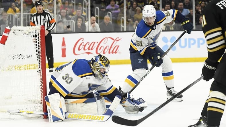 Mar 11, 2024; Boston, Massachusetts, USA;  St. Louis Blues goaltender Joel Hofer (30) gathers the puck in front of St. Louis Blues defenseman Matthew Kessel (51) during the first period against the Boston Bruins at TD Garden. Mandatory Credit: Bob DeChiara-USA TODAY Sports