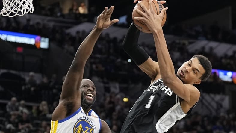 Mar 11, 2024; San Antonio, Texas, USA; San Antonio Spurs forward Victor Wembanyama (1) grabs a rebound away from Golden State Warriors forward Draymond Green (23) during the first half at Frost Bank Center. Mandatory Credit: Scott Wachter-USA TODAY Sports