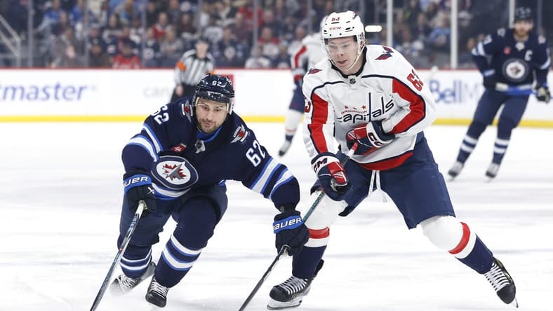 Mar 11, 2024; Winnipeg, Manitoba, CAN; Winnipeg Jets right wing Nino Niederreiter (62) and Washington Capitals left wing Ivan Miroshnichenko (63) chase after the puck in the first period at Canada Life Centre. Mandatory Credit: James Carey Lauder-USA TODAY Sports