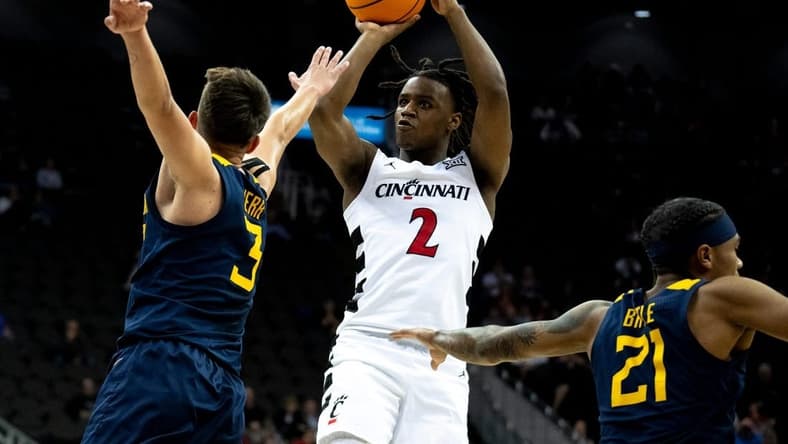 Cincinnati Bearcats guard Jizzle James (2) hits a 3-point basket as West Virginia Mountaineers guard Kerr Kriisa (3) defends in the first half of the Big 12 Conference tournament between Cincinnati Bearcats and West Virginia Mountaineers at T-Mobile Center in Kansas City, Mo., on Tuesday, March 12, 2024.