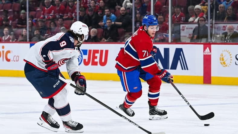 Mar 12, 2024; Montreal, Quebec, CAN; Montreal Canadiens center Jake Evans (71) plays the puck against Columbus Blue Jackets defenseman Ivan Provorov (9) during the first period at Bell Centre. Mandatory Credit: David Kirouac-USA TODAY Sports