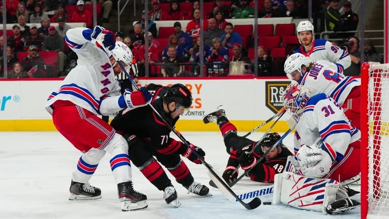 Mar 12, 2024; Raleigh, North Carolina, USA; Carolina Hurricanes right wing Jesper Fast (71) shot attempt is stopped by New York Rangers defenseman Erik Gustafsson (56) and goaltender Igor Shesterkin (31) during the first period at PNC Arena. Mandatory Credit: James Guillory-USA TODAY Sports