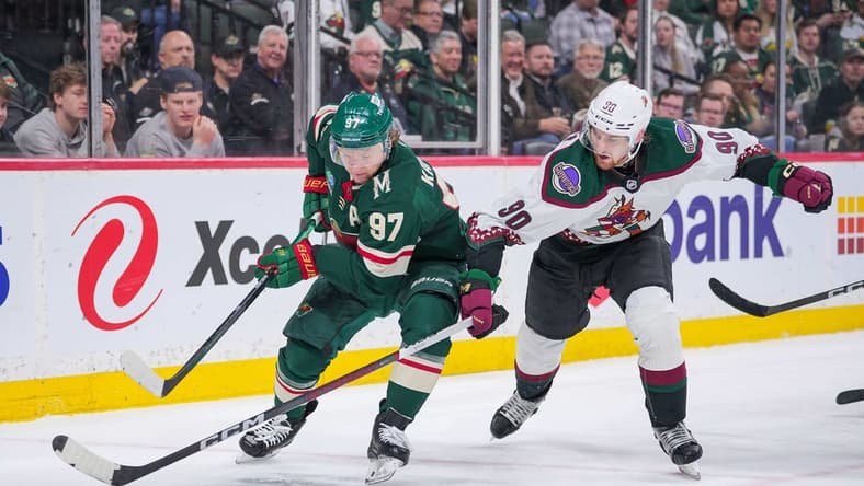 Mar 12, 2024; Saint Paul, Minnesota, USA; Minnesota Wild left wing Kirill Kaprizov (97) skates with the puck against the Arizona Coyotes defenseman J.J. Moser (90) in the second period at Xcel Energy Center. Mandatory Credit: Brad Rempel-USA TODAY Sports
